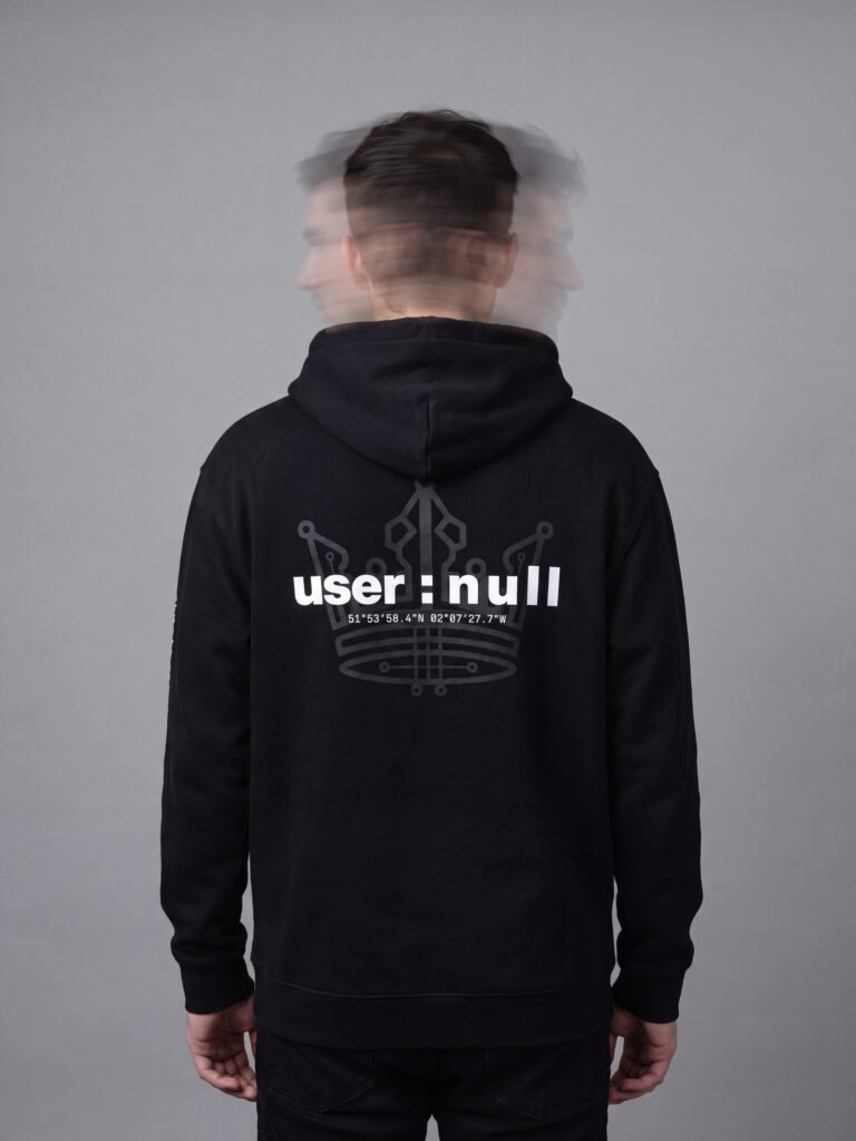 Model wearing the black user : null oversized hoodie, seen from behind with the head blurred by long exposure, showing the circuit crown and user : null print across the shoulder blades