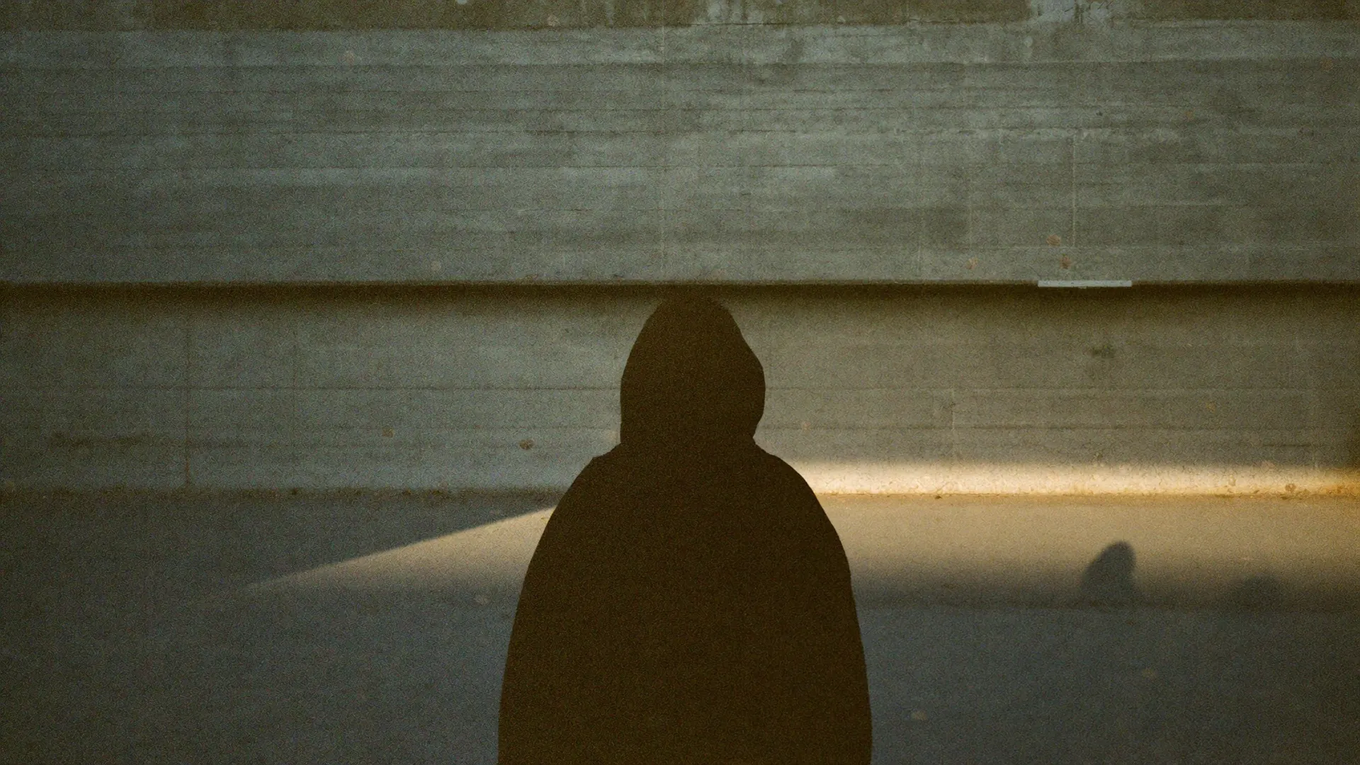 user : null campaign — hooded figure against golden light on concrete